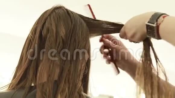 发型师在美发沙龙理发前梳理头发关闭理发师在视频的预览图
