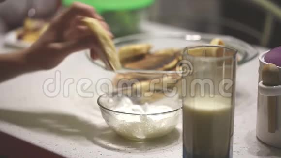 一个十几岁的孩子吃着加了酸奶油的薄煎饼视频的预览图
