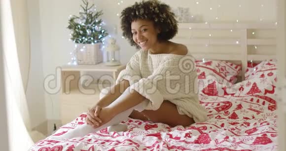 圣诞节时年轻女子在床上放松视频的预览图