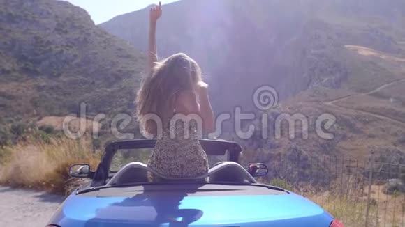 蓝色敞篷车里美丽的金发女孩视频的预览图
