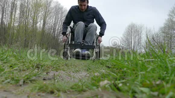 残疾人乘坐轮椅行走自然视频绿色背景视频的预览图