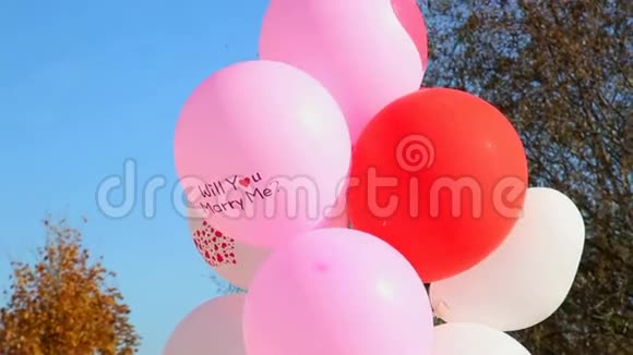 婚礼带着文字的气球你愿意嫁给我吗蓝天背景下的空中气球婚礼装饰视频的预览图