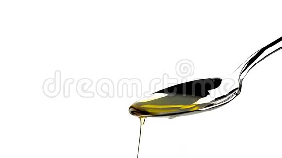 特级初榨橄榄油在勺子上滴在白色背景上视频的预览图