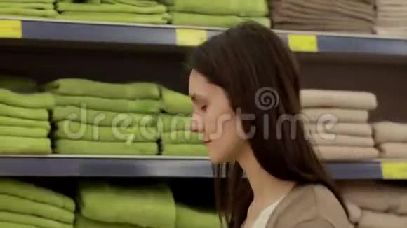 年轻女子在超市里选择毛巾视频的预览图