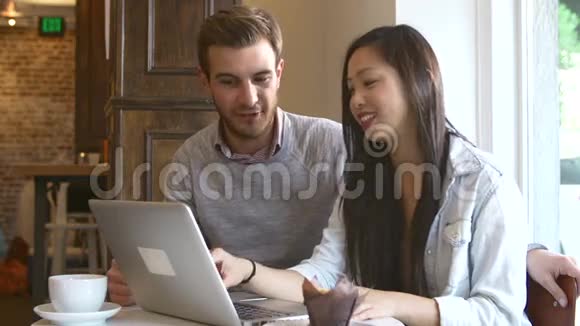 咖啡屋和餐厅使用笔记本电脑的情侣视频的预览图