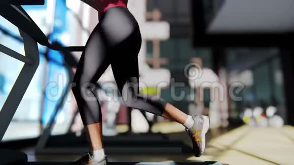 健身房里有不同的健身器材和一个漂亮的女孩在跑步机上跑步视频的预览图