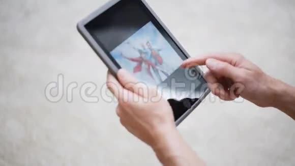 双手拿平板电脑在家看照片视频的预览图