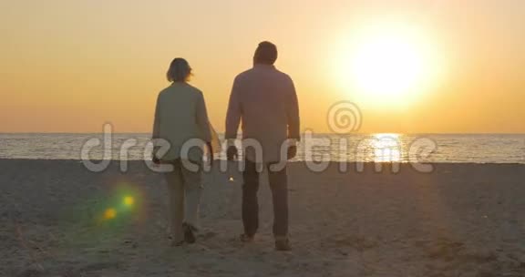 日落时分在海边拥抱的老夫妇视频的预览图