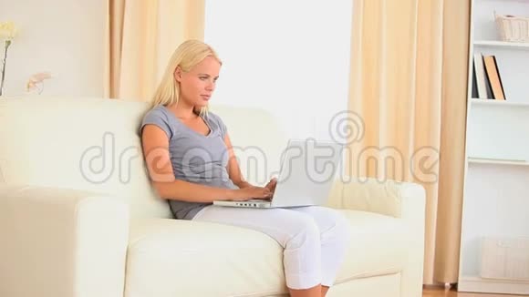 坐在沙发上搜索网络的女人视频的预览图