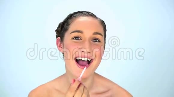 一位抹唇膏的年轻女子视频的预览图