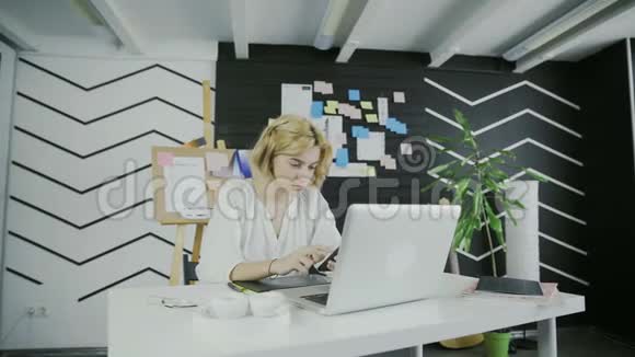 女人在现代办公室用智能手机视频的预览图