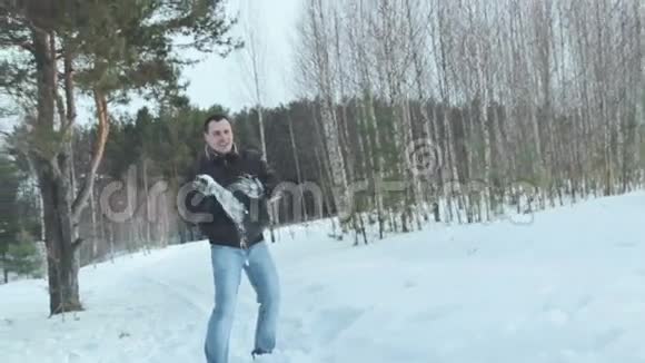 在冬天的森林里打雪仗的夫妇慢动作视频的预览图