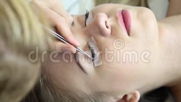 漂亮的年轻女人睫毛延伸长睫毛的女人眼美容师为年轻人士提供睫毛延伸服务视频的预览图