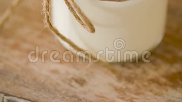 木制桌子上的玻璃瓶里的酸奶或酸奶油视频的预览图
