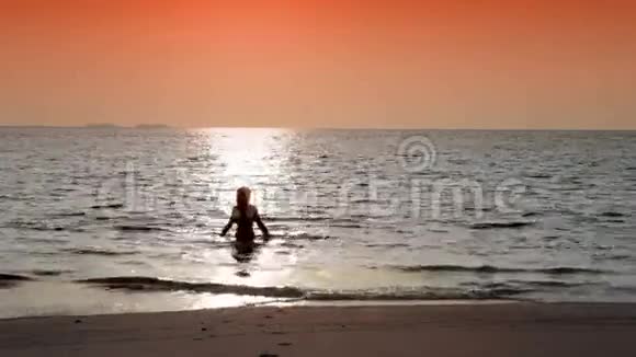 女人在海洋日落时的剪影视频的预览图