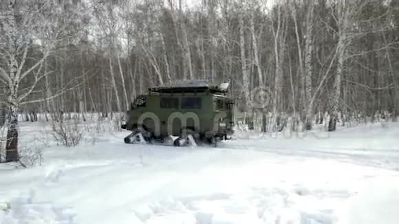 雪地摩托在冬天的树林里穿过深深的雪堆视频的预览图