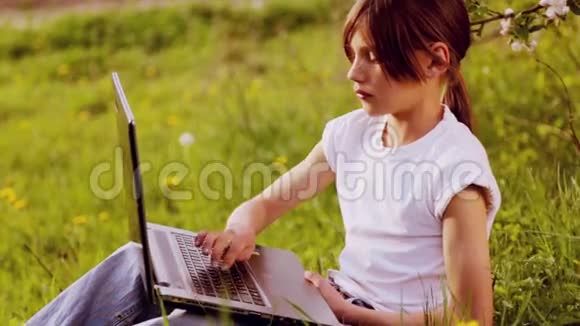 带着笔记本电脑在公园里的白人男孩有笔记本电脑的孩子带手提电脑的乡下少年视频的预览图