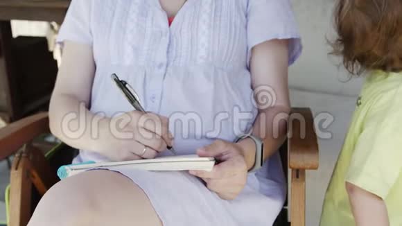 戴墨镜的女孩在笔记本上画素描视频的预览图