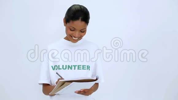 志愿者妇女在笔记本上思考和书写视频的预览图