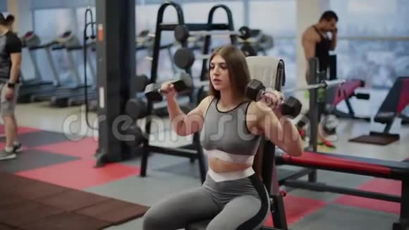 非常漂亮的健身女在健身房用哑铃锻炼视频的预览图