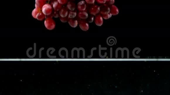 黑色背景下落入水中的葡萄视频的预览图