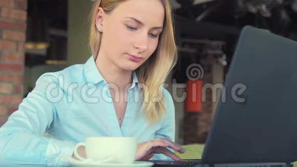 咖啡屋里有笔记本电脑的年轻快乐女人视频的预览图