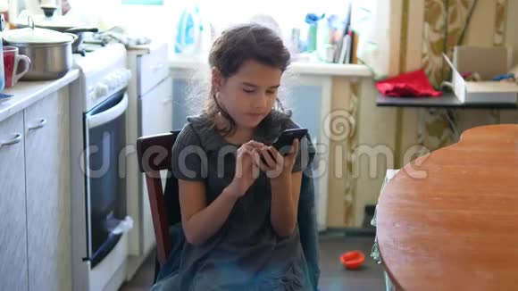 厨房里的女孩在玩智能手机网游早餐视频的预览图