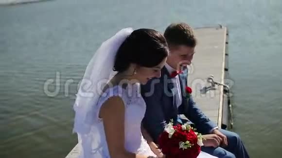美丽快乐的新娘新郎坐着视频的预览图