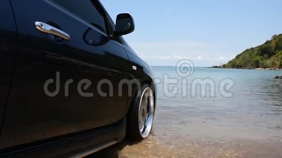 带有镀铬轮子的汽车在海滩的海边公园视频的预览图