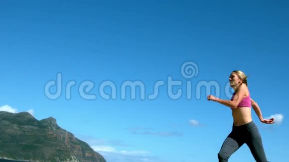 适合金发女郎在海滩上奔跑和跳跃视频的预览图