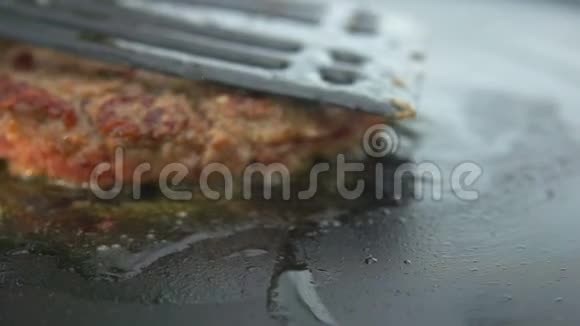 牛肉汉堡在烤架上翻转视频的预览图