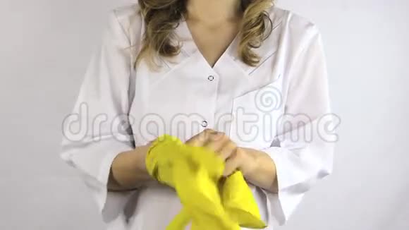 穿白色长袍的女人手上戴着黄色橡胶手套视频的预览图