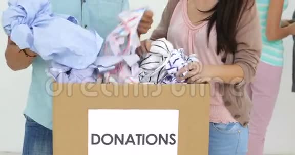 一队微笑的工人穿过捐赠箱的衣服视频的预览图