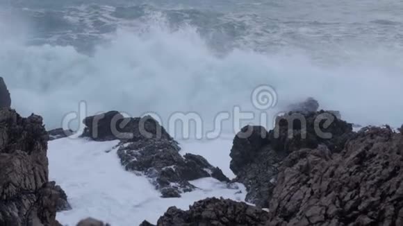 巨大的波浪在石头上破碎缓慢的运动视频的预览图