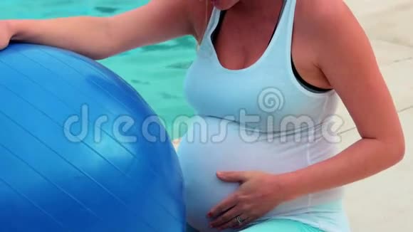 孕妇摸着肚子拿着健身球视频的预览图