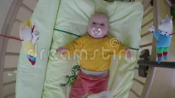 有兴趣的宝宝看着旋转木马玩具在她的床上旋转4K视频的预览图