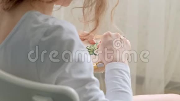 那个女人正在绣一张花叶在织物上的照片家用工艺品视频的预览图