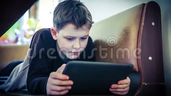 青少年男孩玩平板电脑颜色交叉过程视频的预览图