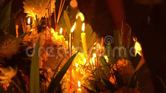 佛日在佛寺人们点燃蜡烛鲜花和香棒沃特纳哈拉姆普吉泰国慢慢视频的预览图