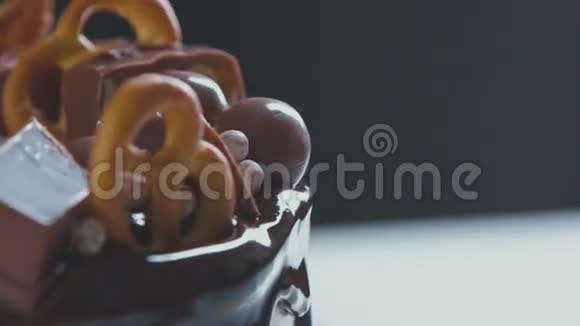 糕点带有巧克力糖霜巧克力和椒盐卷饼的白色奶油蛋糕视频的预览图