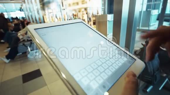 女子在机场候机室使用平板电脑视频的预览图