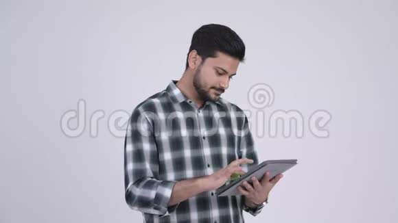 年轻快乐留胡子的印度男人使用数码平板电脑的肖像视频的预览图