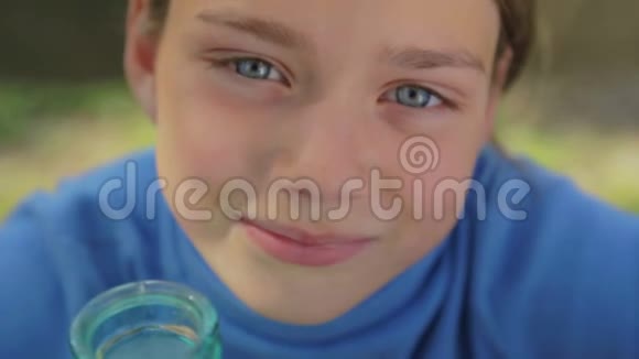 一个健康的孩子和一杯牛奶的肖像一个男孩在大自然中喝牛奶健康的饮食视频的预览图