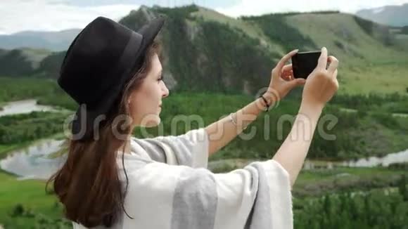 女徒步旅行者用智能手机拍照山顶悬崖视频的预览图