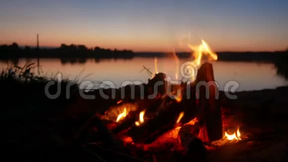 在海滩上美丽的日落时篝火视频的预览图