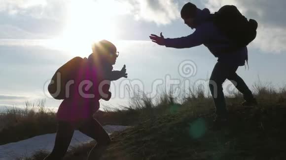 两个徒步旅行在山上互相帮助团队合作情侣徒步旅行互相帮助信任帮助日落视频的预览图