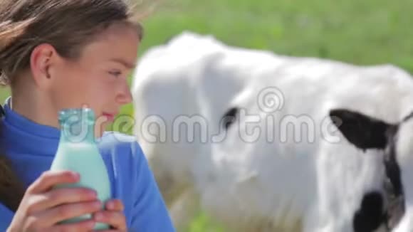 一个健康的孩子和一杯牛奶的肖像一个男孩在大自然中喝牛奶健康的饮食正确的方法视频的预览图