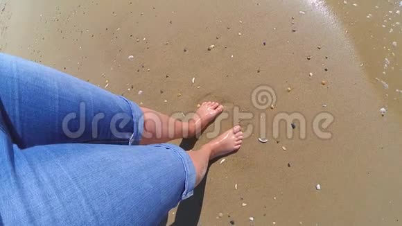 女孩站在海边海浪拍打着她的脚视频的预览图
