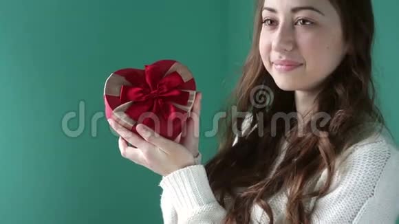 美丽的女孩拿着一个红色的蝴蝶结的礼物视频的预览图