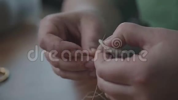 女裁缝的手拿着针头和零件视频的预览图